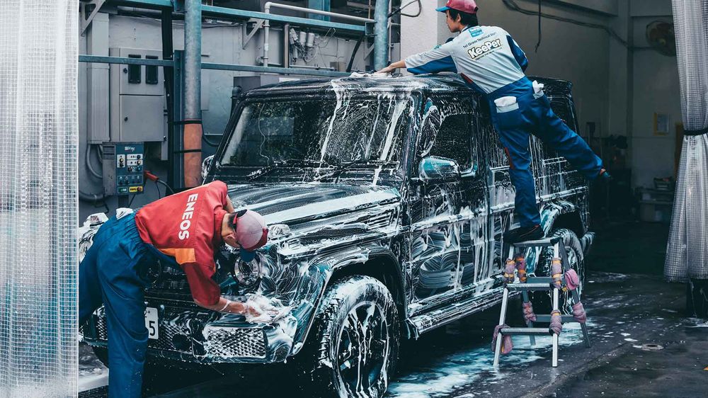 A car being hand washed with foam during a valet