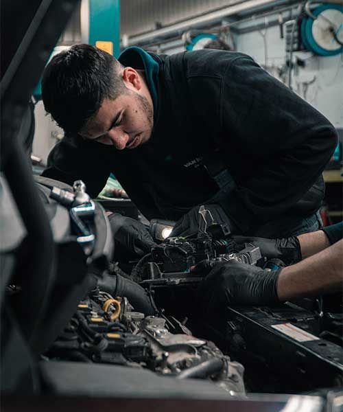 Mechanic working in the engine bay of a car